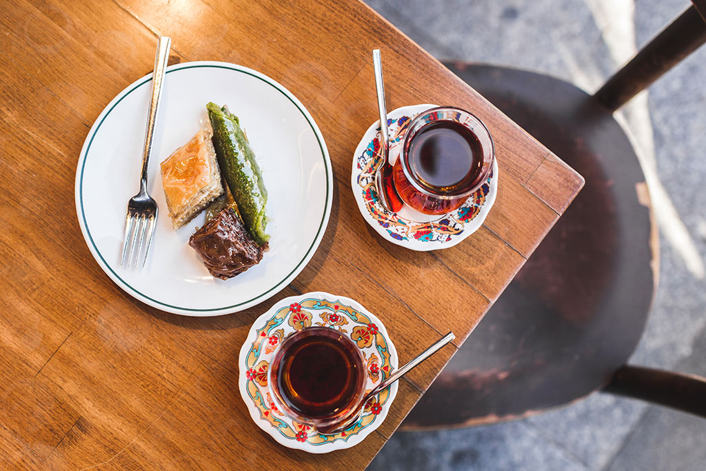 Mrs. Smith enjoys ______ some tea with her friends in the afternoon.